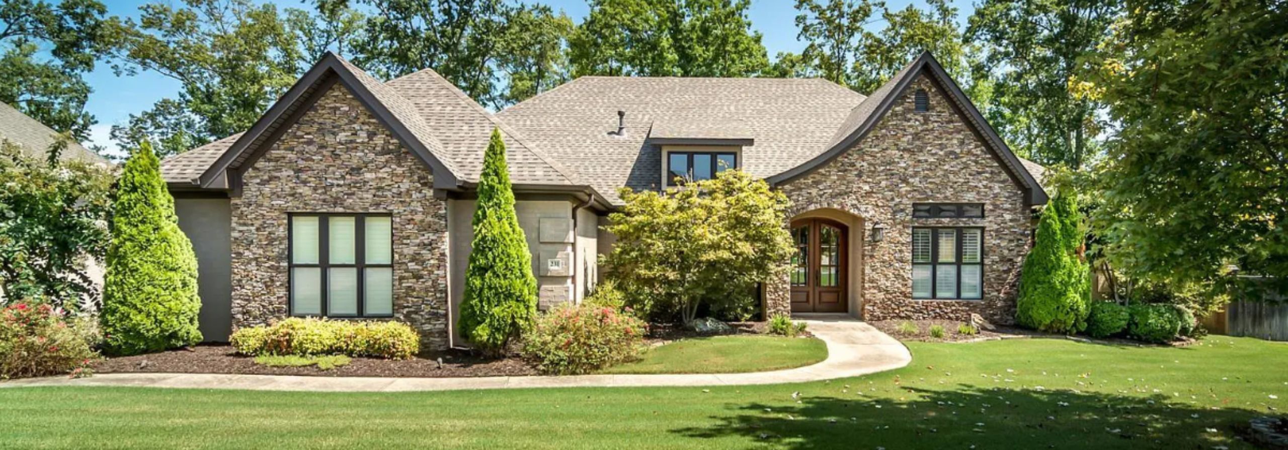 Gorgeous brown family home with a manicured lawn and winding entry way path